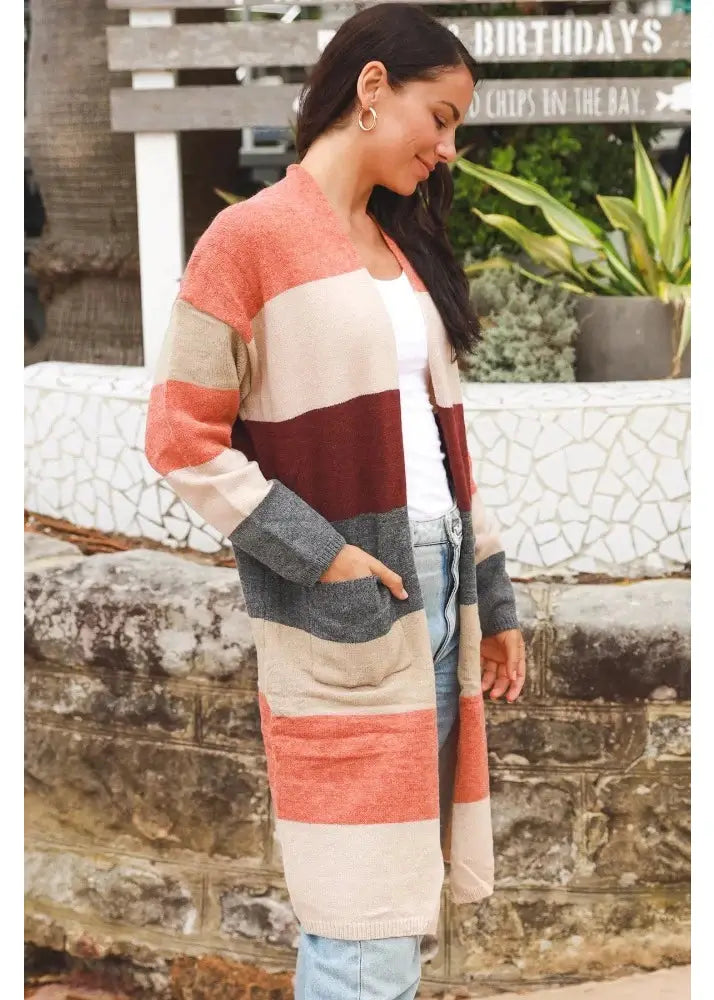 Women's above the knee, open-front cardigan with horizontal stripes in beige, rust, burgundy, and grey. Features ribbed cuffs and patch pockets